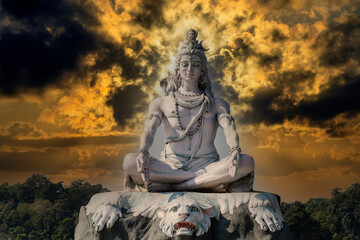 Fototapeta premium Statue of meditating Hindu god Shiva on the Ganges River at Rishikesh village in India