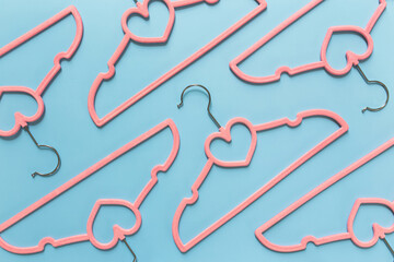 Black Friday or clothing industry concept on blue background with pink hangers