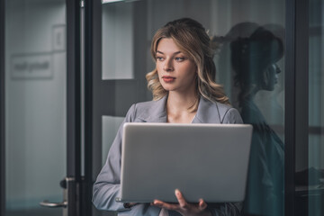 Business young woman standing with open laptop