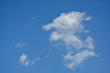 Beautiful cumulus clouds against the blue daytime sky.