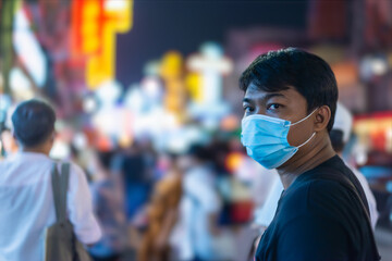 Fototapeta na wymiar COVID-19 Man in city street wearing face mask protective for spreading of Coronavirus Disease in Thailand,. Portrait of man with surgical mask on face against SARS-CoV-2.