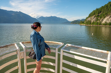 A woman on the promenade dock at Porteau Provincial Park on Hoe Sound, near Squamish and Whistler BC.