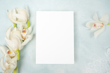 Fototapeta na wymiar Beautiful white orchid and blank card flat lay
