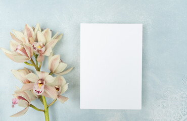 Floral flat lay with orchid flower and blank card
