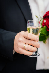 Sektglas in der Hand des Bräutigam nach der Hochzeit