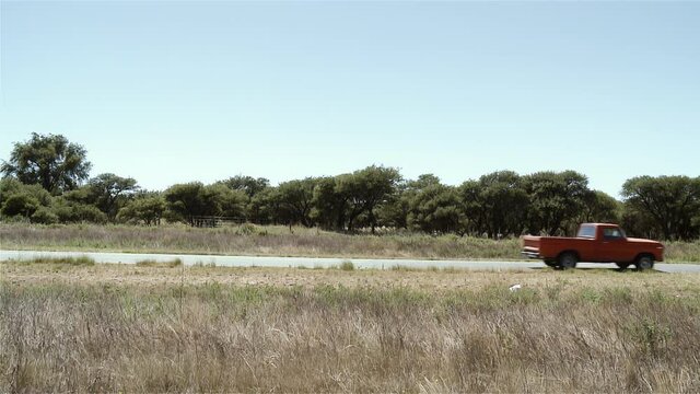 Old Red Pickup Truck on a Rural Road in Argentina. Side Angle View. 4K Resolution.