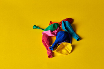 unfilled balloons lie on a yellow background