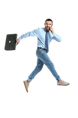 Jumping young man talking by mobile phone on white background