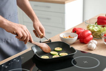 Man frying vegetables in kitchen, closeup