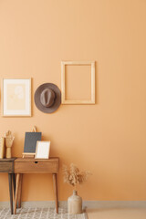 Interior of stylish room with table and hat hanging on color wall