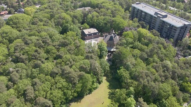 Flying up to classic manor hidden in green forest