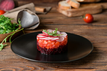 Plate of delicious tartare salad on wooden table, closeup