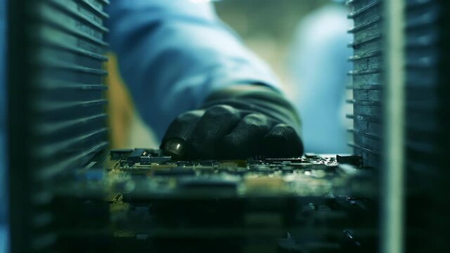 Assembly Line Worker putting a Printed Circuit Board into a Rack Holder Inside a Computer Factory. Close Up. 4K Resolution.