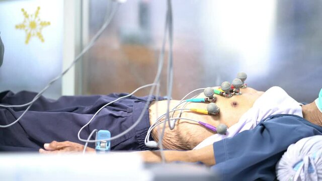 ECG or EKG Legs of man with electrodes for electrocardiogram records on bed in hospital