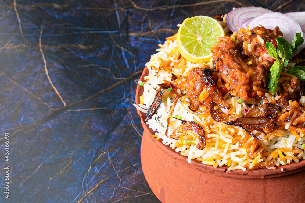 Wall mural Top shot of Paneer Rice Biryani in Mud Pot garnished with lemon and onion slices. - Wall murals