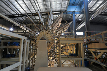 Fototapeta premium Workers control machinery to produce plates on the production line