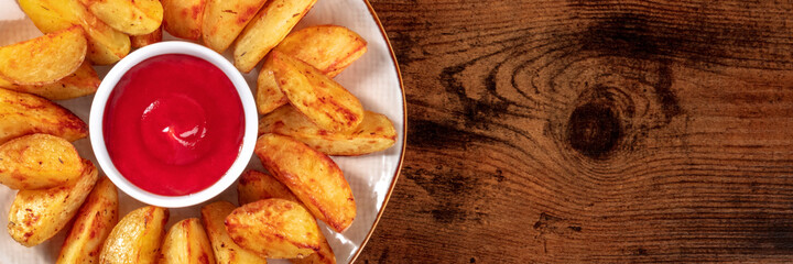 Baked potato wedges close-up panorama, top shot