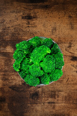 Boiled broccoli, shot from above on a dark rustic wooden background