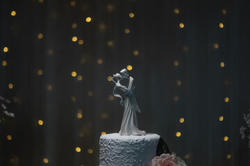 couple on top of wedding cake with flowers