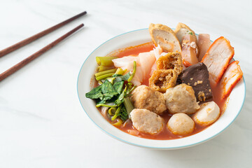 noodles with meatballs in pink soup