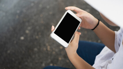 Cropped shot of female holding horizontal smart phone.