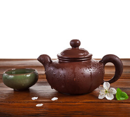 Obraz na płótnie Canvas Cup of green tea and clay teapot with cherry flowers isolated on a white background. 