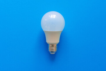 One light bulb on a blue paper background