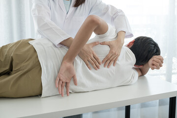 Female physiotherapists provide physical assistance to male patients with back injuries back massages for relaxation and muscle recovery in the rehabilitation center