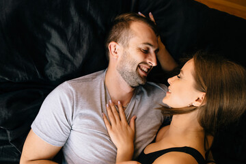 A couple in love lying on a bed cuddling