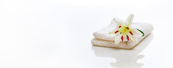 White spa towels with lily on white and reflection