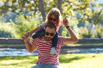 Single father and little daughter enjoying in the park.