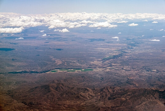 Aerial view over Rincon Mountains to irrigated fields and river valley near Benson, Arizona