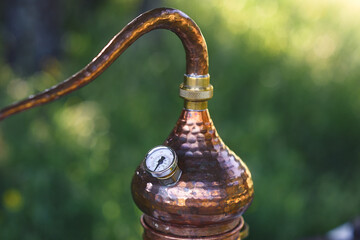 Top detail of antique copper alembic with temperature thermometer - obrazy, fototapety, plakaty