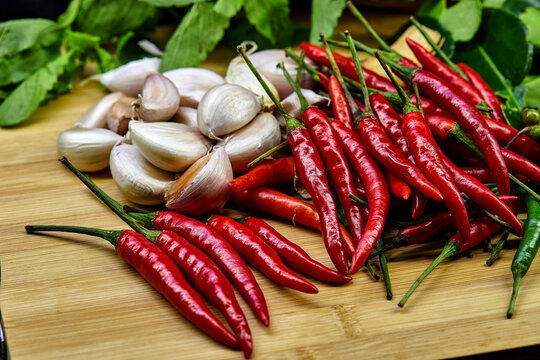 red chili peppers and garlics on  wooden board