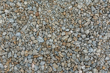 Coarse and fine gravel and crushed stone as a road surface. As a natural stone background.