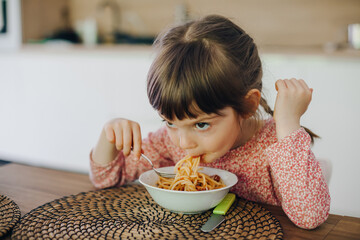 little girl eating spaghetti