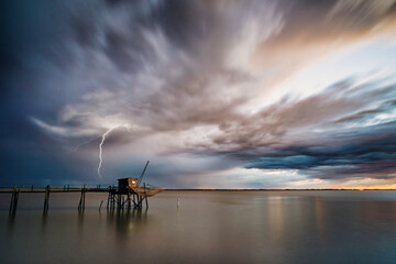 Calm sea and thunderstorm on horizon with dramatic storm clouds on Atlantic coast of Charente...
