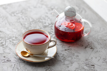 Obraz na płótnie Canvas Berry tea in glass teapot on gray surface