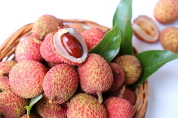 Bunch of fresh ripe lychee fruit with green leaves on white background. Exotic or tropical litchi fruit. Lichi. Copy space.