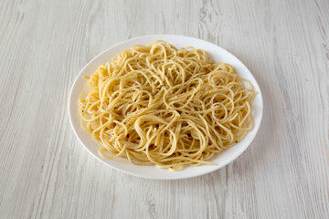 Homemade Cacio E Pepe Pasta with Pecorino Romano and Pepper on a white plate, side view.