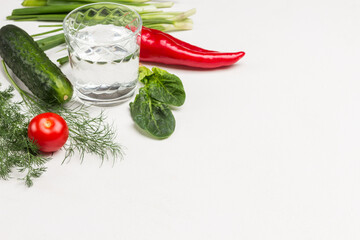 Glass of water, spinach leaves and vegetables.