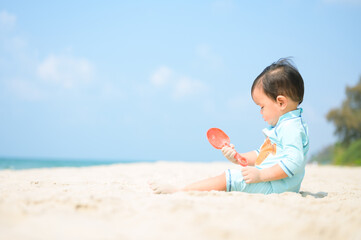 Kid playing with sand on the beach by the sea. holidays with children near the sea.