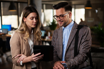 Colleagues talking in the office. Businesswoman and businessman discussing work in office.