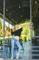 A young sports girl stands on a summer veranda. Bright sunlight falls on the girl.