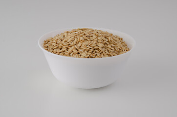 White plate with dry oatmeal on a clean background. 