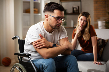 Obraz premium Young sad man in a wheelchair. Girlfriend comforting her sad boyfriend.