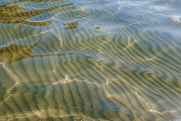 Crystal clear water rippled and sunny reflections