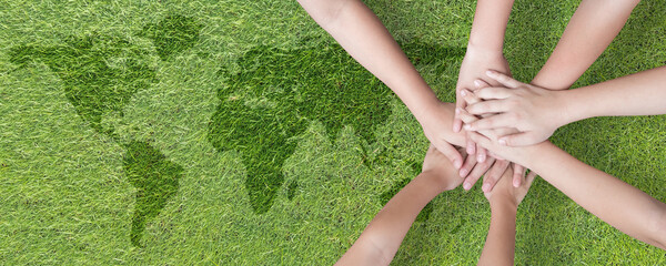 World environment day with global community teamwork, CSR and ESG environmental energy saving collaboration of young children hands stack together on green background for sustainable development goal - obrazy, fototapety, plakaty