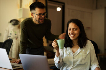 Colleagues drinking coffee in office. Businesswoman and businessman enjoying in fresh coffee while working