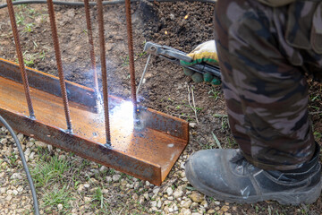 A welder welds metal at a construction site.